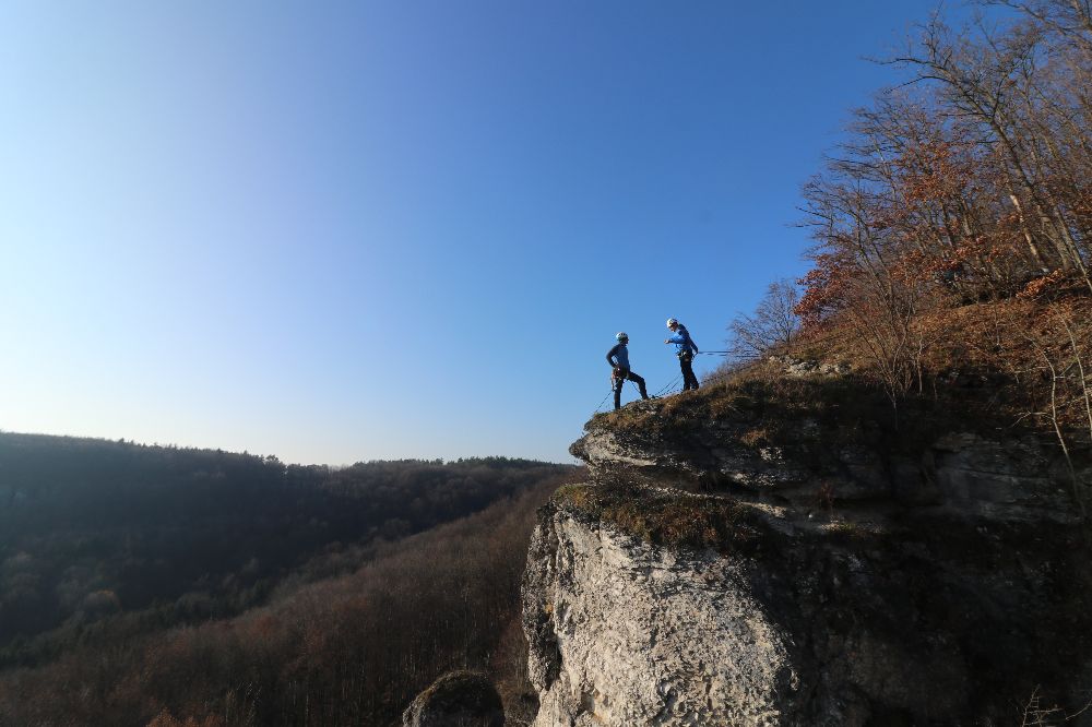 Zwei Sachbearbeiter für Kletterunfälle sprechen sich oberhalb der Unfallstelle über ihr weiteres Vorgehen ab. Zuvor hatten Mitarbeiter der Bergwacht Bamberg die Abseilstelle eingerichtet.