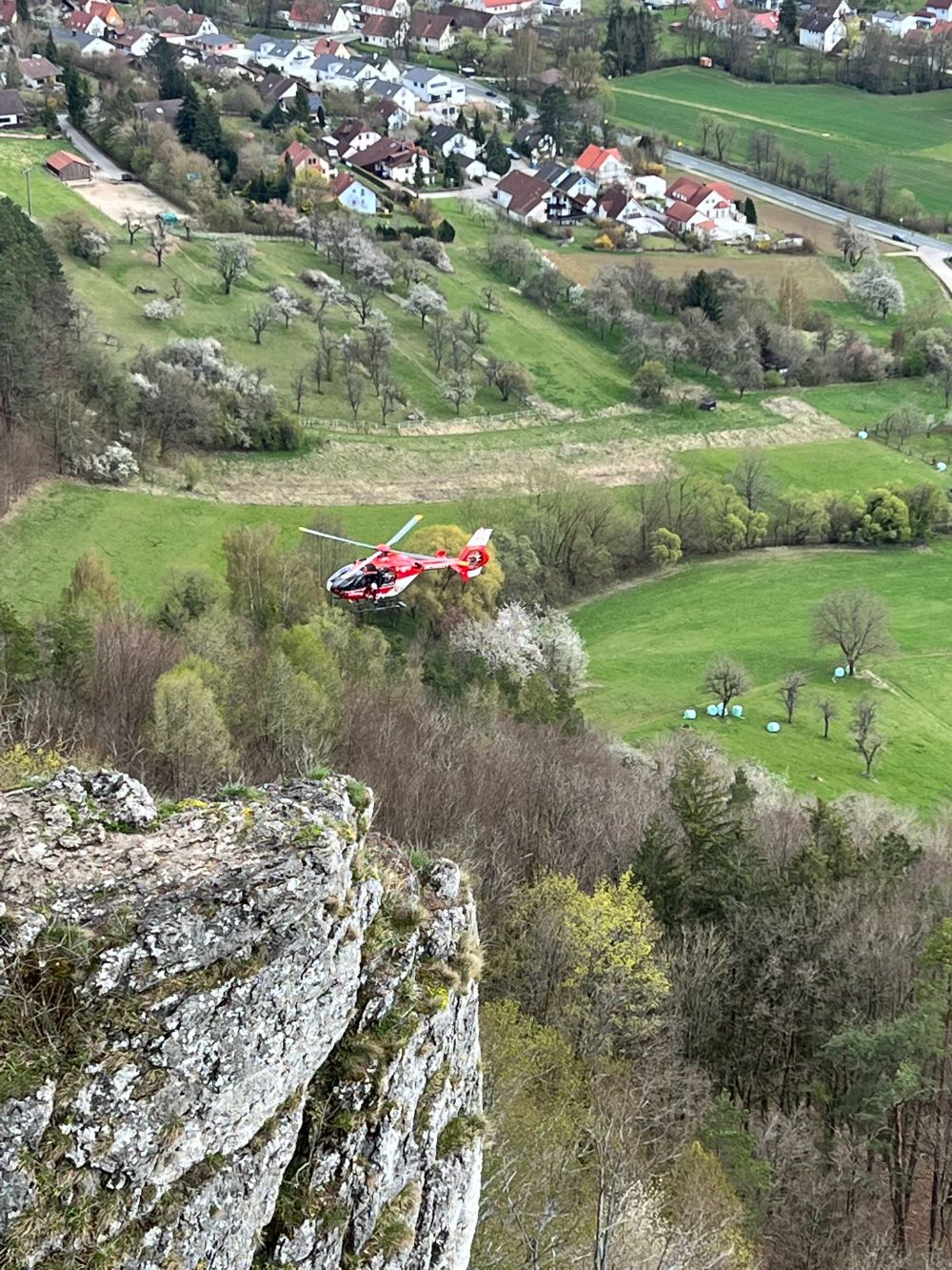 Der Rettungshubschrauber kreist über dem Hohlen Fels oberhalb des Happurger Stausees (Bild: Bergwacht Frankenjura)