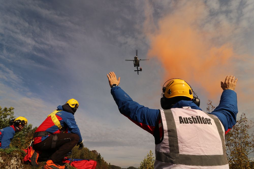 Anflug des Polizeihubschraubers zu einem Verletzten: Ein Ausbilder der Bergwacht weist den Piloten ein