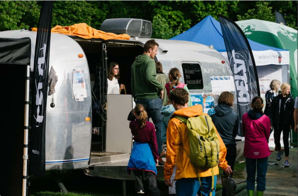 Viel Regen beim letzten Kletterfestival: Dennoch herrscht emsiges Treiben vor dem Airstream-Caravan, der Gallionsfigur der Veranstaltung (Bild: Simon Toprak)