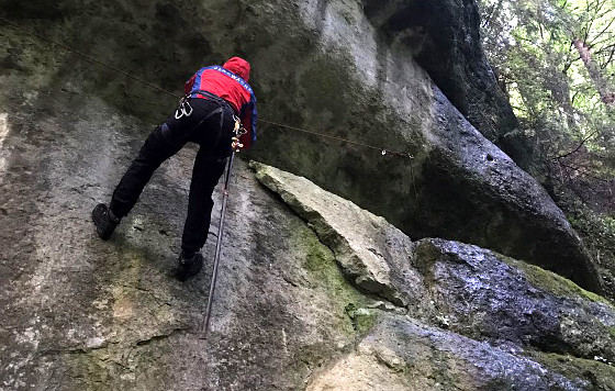 Ein Aktiver der Bergwacht sondiert das Gelände vor der Entfernung der spitz zulaufenden, hellen Felsschuppe, die sich gelockert hatte